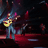 A 48x48 pixel animated buddy icon featuring a cartoon musician playing guitar on stage with green text "Original Icons .com" on the right side, displayed as a contact sheet of two frames.