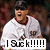 Pixelated image of a person in white sports uniform with dark cap and red collar, holding text banner reading 'I Suck!' with multiple exclamation marks.