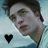 A person with dark hair and light skin wears a light blue shirt against a blurred light blue background with a black heart symbol in the lower-left corner.