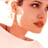 Pixelated close-up of a person's face and shoulder in profile view with warm skin tones against white background.