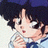 Pixelated anime-style character with dark hair and blue clothing, next to black background with white text reading 'Anime IM' and 'com' in stylized font.