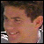 Pixelated close-up of a person's face with closed eyes, light skin tone, and short brown hair, set against a dark background with white and gray pixel clusters.