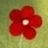 A static pixelated image of a red flower with five rounded petals and a light center on a greenish-yellow background.