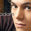 A close-up of a person's face with visible eyes, nose, and mouth, overlaid with the text 'adam' and scattered white dots on a dark background.