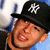 Pixelated close-up of a person wearing a black cap with white 'NY' logo, red lips, and visible neck.