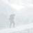 Animated sequence of a figure in dark clothing ascending a snowy mountain slope with a backpack, viewed from multiple angles.