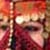 Pixelated static image with warm red and orange tones, featuring indistinct shapes and blurred forms in a low-resolution composition.