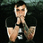 Pixelated image of a person in black clothing with hands clasped near the face, next to pink text reading 'please mommy...!!' on a dark background.
