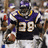 A pixelated image of a football player in a purple and white uniform with the number 29, holding a football against a yellow background with text.