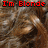 A pixelated image of brown curly hair with red and white text overlays reading "I'm Blonde" at top left, "BE" at top right, and "JEALOUS" at bottom center.