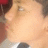 Pixelated close-up of a person's face with light skin tone, visible eye and nose area, dark hair on left side, red object top-left corner.