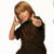 Pixelated image of a person with light brown hair wearing dark clothing, making a hand gesture near their face against a white background.