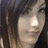 Pixelated close-up of a person's face with dark hair, light skin tone, and visible eyes against a dark background.