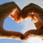 Two figures with brown hair embrace in a heart-shaped frame against a light blue background.