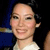 A static pixelated image shows a person with light skin, dark hair, and a white top against a dark background with blue and yellow elements.