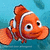 Pixelated orange clownfish with white stripes swims against blue background, displaying slight head rotation and text overlay in bottom-left