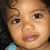 A child with curly dark hair and a light blue top appears in four showing subtle facial expression changes
