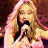 A pixelated image of a woman singing into a microphone on the left, with green text reading "Original Icons .com" on a dark background to the right.