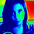 A thermal-imaged portrait of a person with long dark hair, wearing a dark top, holding a red and green object against a dark background.