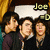 Three people pose together in a group photo with text labels above each person's head, showing different names and emoticons across frames.