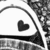 Black and white pixelated icon featuring a dark heart shape inside a curved arrow outline on a light background.