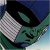 Pixelated image of a stylized face with dark hair, greenish skin tones, and a checkered pattern on the left side against a blue background.