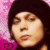 Static pixelated image of a person's face with dark hair against a pink gradient background, rendered in low-resolution 256x256 pixels.
