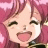 Pixelated anime-style icon of a character with pink hair and closed eyes smiling widely, set against a soft pink background.