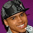 Pixelated image of a person wearing a dark cap and light shirt against purple background, with red 'G' text on right side.