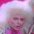 Pixelated image of a person with light-colored hair wearing pink clothing against a gradient background.