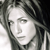 Pixelated grayscale portrait of a person with shoulder-length hair, neutral expression, and visible facial features including eyes, nose, and mouth.