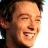 A 48x48 pixel buddy icon featuring a side-profile of a person with curly hair and a smiling expression on the left, next to green text reading "Original Icons .com" on a dark green background.