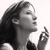 Black-and-white pixelated profile of a woman with long dark hair, closed eyes, and hand raised near her face in a contemplative pose against a plain background.