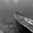 A grayscale pixelated image with a diagonal gradient from light to dark, featuring indistinct shapes and no recognizable subjects or text.