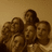Pixelated image of four people in a group pose with a sepia-toned background and pink pixelated text reading "what are we looking at???"