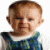 A 2x2 contact sheet of a pixelated baby image with text overlays in pink and cyan, displayed on a gray background.