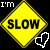 Yellow diamond-shaped sign with black border and text 'SLOW' on yellow background, white pixelated 'I'M' in top-left corner, white cursor icon pointing at sign bottom-right.