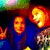 Two pixelated figures in blue clothing with orange faces and red hair, next to a black-and-white peace symbol on white background.