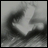 A 48x48 pixel grayscale contact sheet showing two animated frames of a blurry, abstract character face on the left and text elements on the right against a black background.