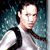 Pixelated image of a person with short dark hair wearing a white shirt with black shoulder accents against a blue-green gradient background.