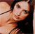 Pixelated close-up of a person with dark hair and light skin, wearing a dark top, against a light background.