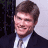 A 48x48 pixel buddy icon split into two frames showing a man in formal attire on the left and green text logo on the right, with visible pixelation and dithering effects.