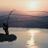 Animated fishing scene showing a person casting a line at sunset over water, with visible frame-to-frame motion of the fishing rod and sun reflection.