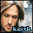 Pixelated portrait of a person with long brown hair, two heart symbols in top corners, and blue text reading 'keith' at bottom.