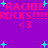 Pixelated text and symbols on a purple background with cyan stars, repeating 'RACHIE ROCKS!!!' and '<3' in pink.