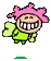 Pixelated character with pink spiky hair, green outfit, and wide grin showing large white teeth; two poses show left arm raised in a thumbs-up gesture.