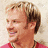 A split-screen image shows a person with light brown hair in two ; the top has text 'Phil Vassar' on black background, bottom has partial text overlays