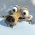 Pixelated cartoon dog with large eyes and open mouth, lying on back against light blue background.