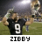 A football player in a black jersey with number 9 raises both arms while holding a trophy, displayed
