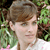 Static 50x50 pixel icon showing a person with brown hair and light skin against green foliage background, rendered in low-resolution pixel art style.